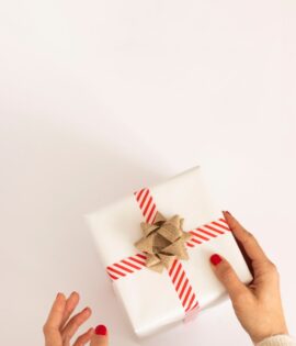 person holding white and red gift box