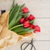 red tulip flowers bouquet on brown wooden pallet